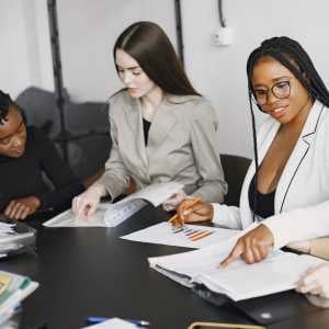 3-employees-at-a-conference-table-working-on-reportsd-charts