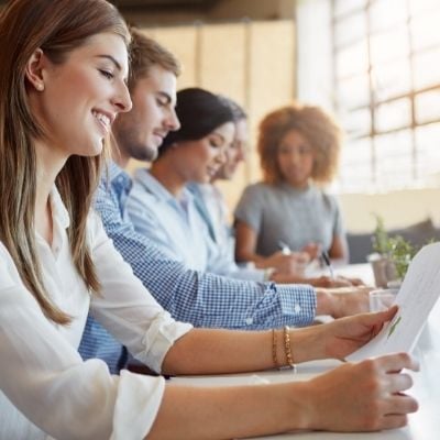 5-people-sitting-at-a-table-looking-at-documents