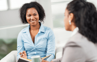 Two women engaged in an interview in a comfortable setting