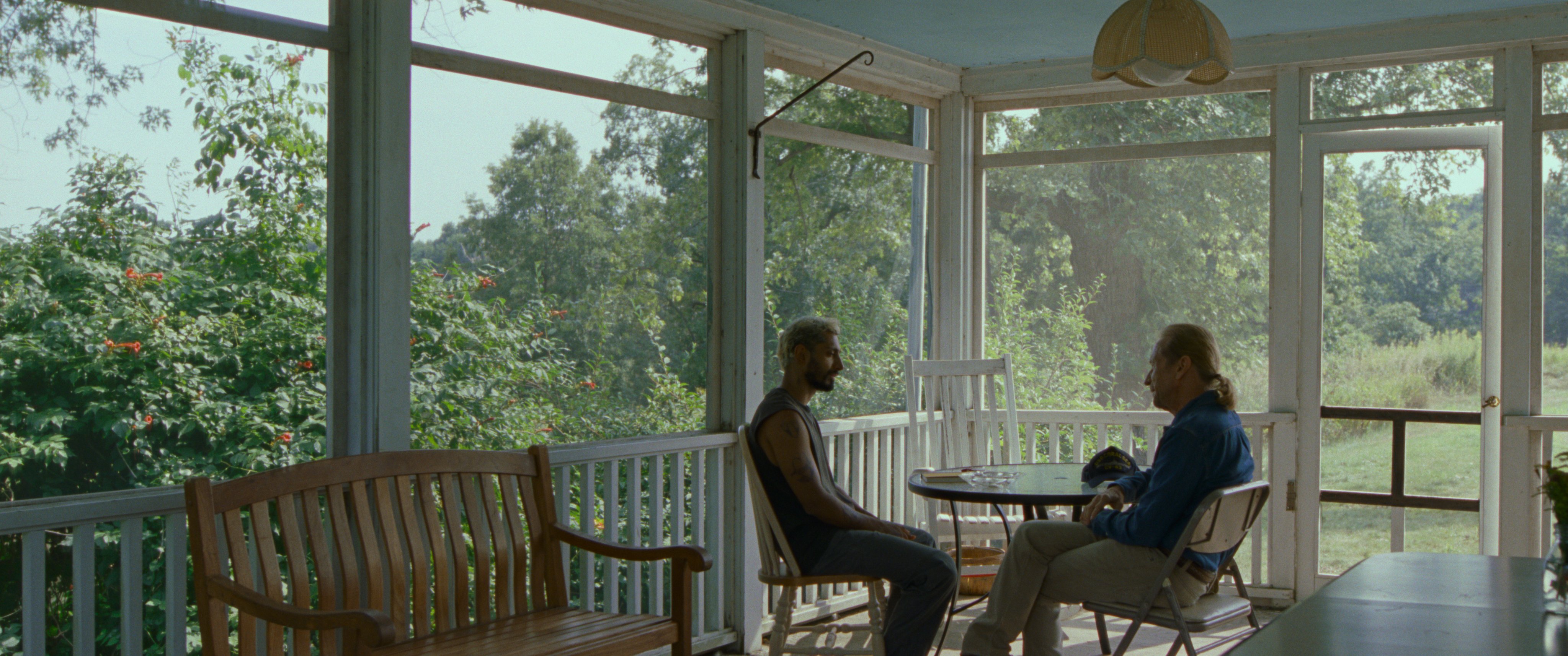 Ruben sits outside on a porch with a teacher