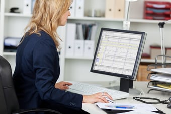 Businesswoman creating a large spreadsheet on her computer