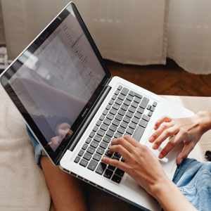 a laptop on a lap with hands on the keyboard, creating an accessible text document