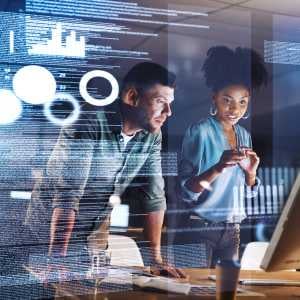 a man and a woman looking at a computer monitor with computer code imposed over the image