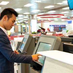 a man using a kiosk and his mobile phone