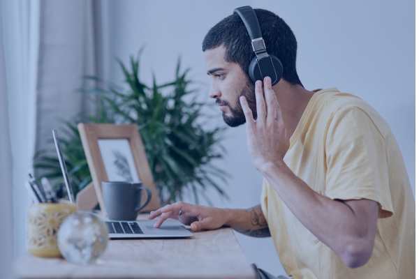 a man with large headphones on using a laptop at a desk