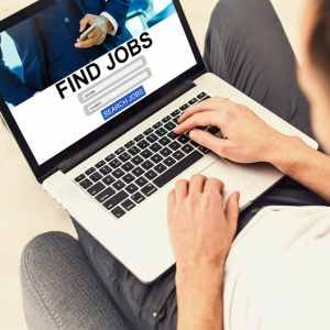 a-laptop-on-apersons-lap-hands-on-the-keyboard-with-Find-Jobs-on-the-screen-with-a-search-jobs-button