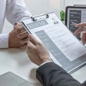 job-interviewer-looking-at-applicant-resume-on-clipboard