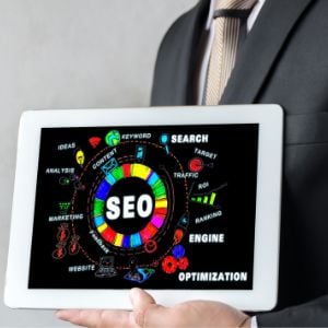 man-holding-tablet-displating-the-term-SEO-and-all-the-components-that-go-into-SEO