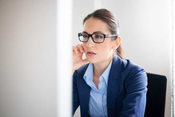 women-with-glasses-looking-at-a-large-monitor